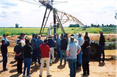 A group of people watching an irrigation system performance check