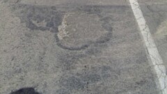 Road pavement that is cracked and potholed as a result of being affected by waterlogging and salinity.