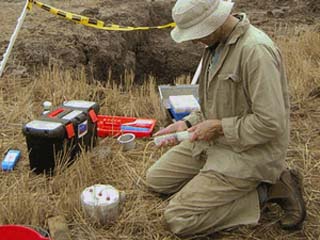 Scientist carrying out soil test in the field